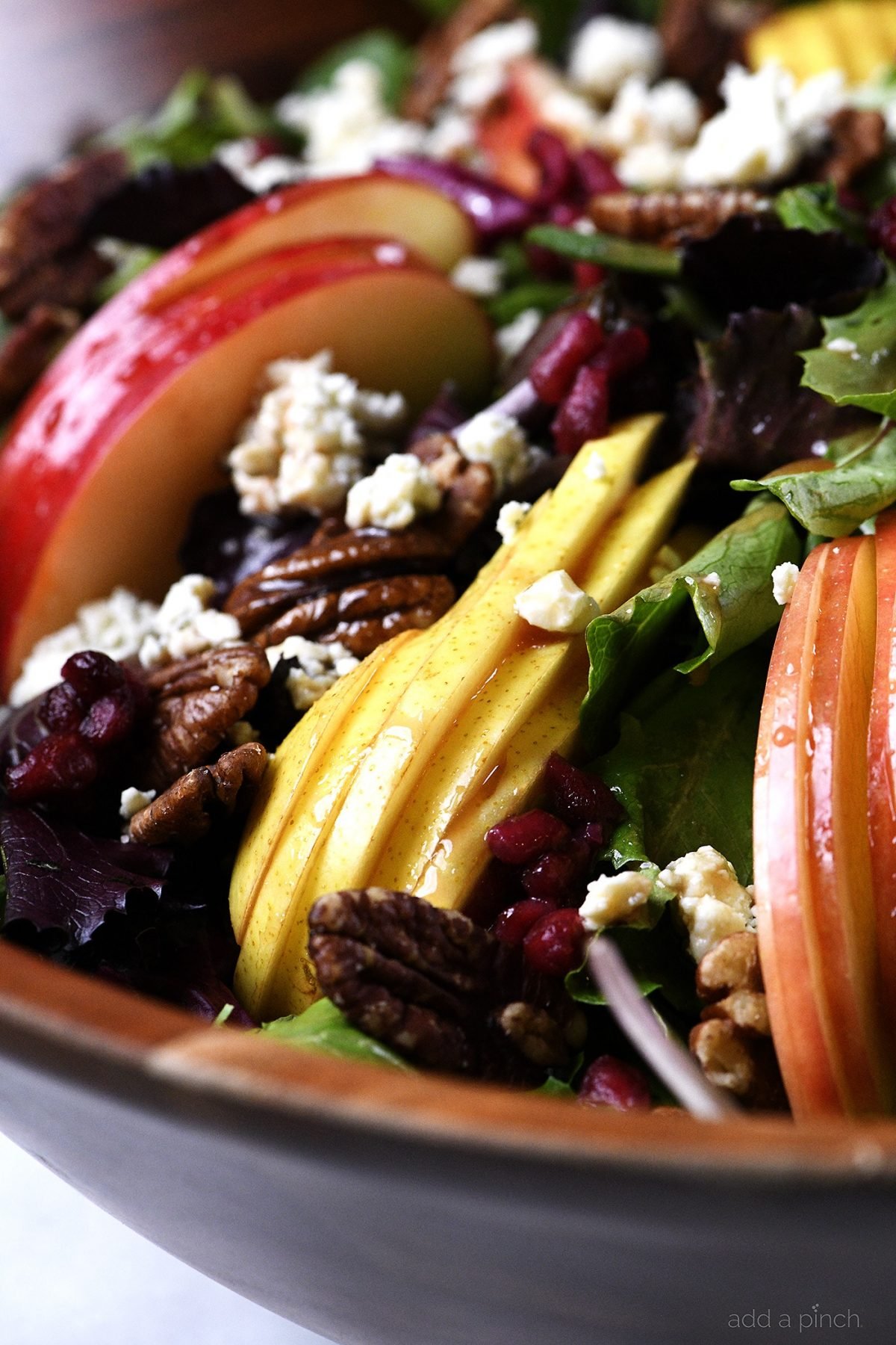 Apple Pear Salad Recipe - This Apple Pear Salad with Pomegranate Vinaigrette makes a delicious salad anytime of year, but especially throughout the holidays. // addapinch.com