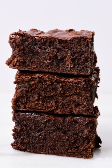 Stack of the best brownies on a marble countertop with a white background.