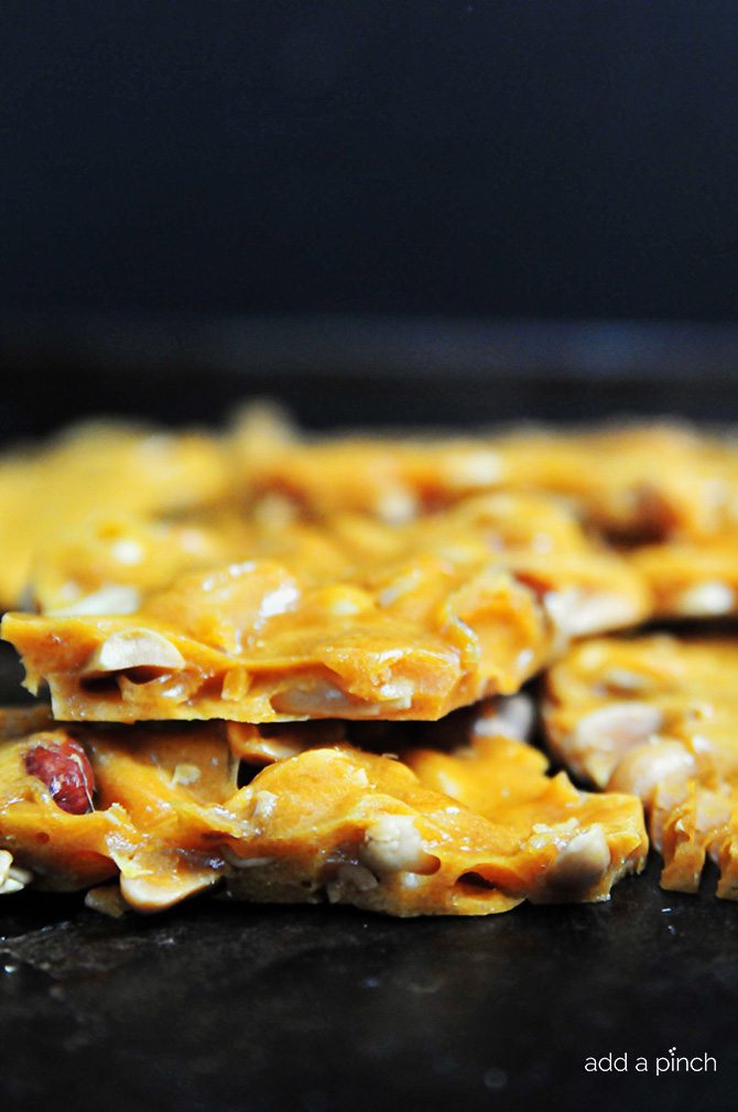 Close up side view of broken pieces of peanut brittle. 