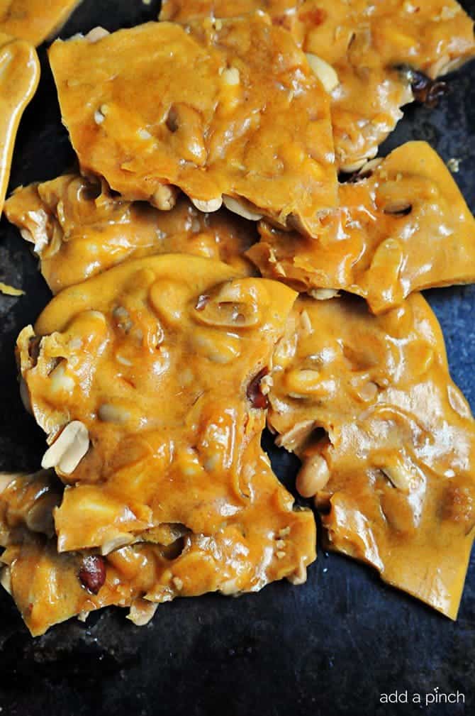 Peanut Brittle Recipe - Peanut Brittle is a delicious, old-fashioned, buttery treat. This peanut brittle recipe has been handed down through the generations and is always a favorite! // addapinch.com