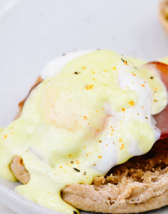 Eggs Benedict Recipe - Toasted English muffins topped with ham, bacon, or Canadian-style bacon, and poached eggs and then drizzled with hollandaise sauce make this a favorite brunch recipe. // addapinch.com