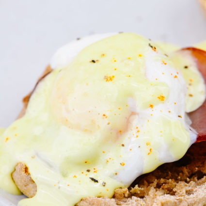 Eggs Benedict Recipe - Toasted English muffins topped with ham, bacon, or Canadian-style bacon, and poached eggs and then drizzled with hollandaise sauce make this a favorite brunch recipe. // addapinch.com