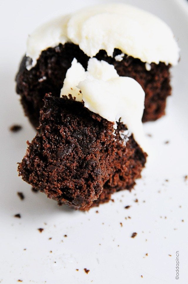 Photograph of chocolate cupcakes with white buttercream frosting.