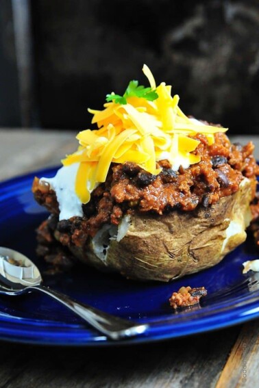 Chili Stuffed Baked Potatoes Recipe - Oh my! These chili stuffed baked potatoes are deee-lish-us! And pretty perfect for the Super Bowl this weekend. // addapinch.com