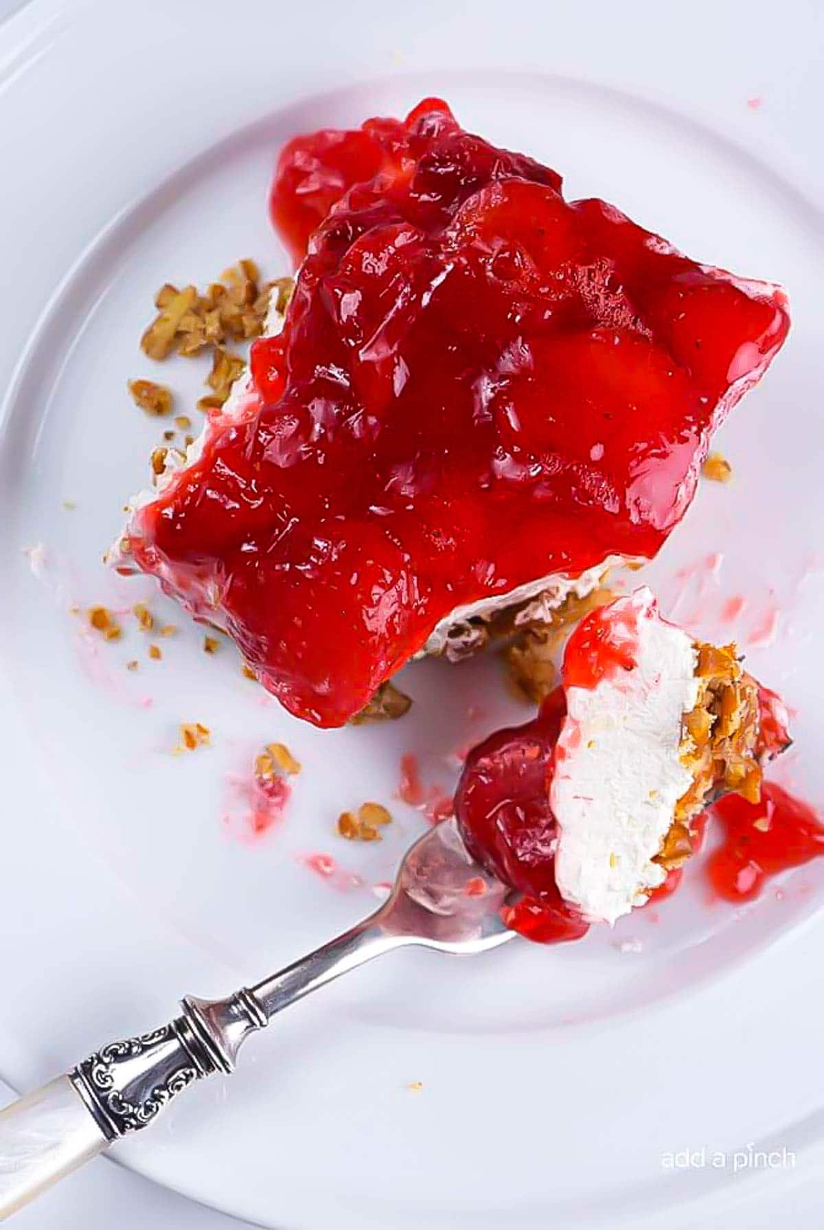 Strawberry Pretzel Salad on plate with fork - addapinch.com