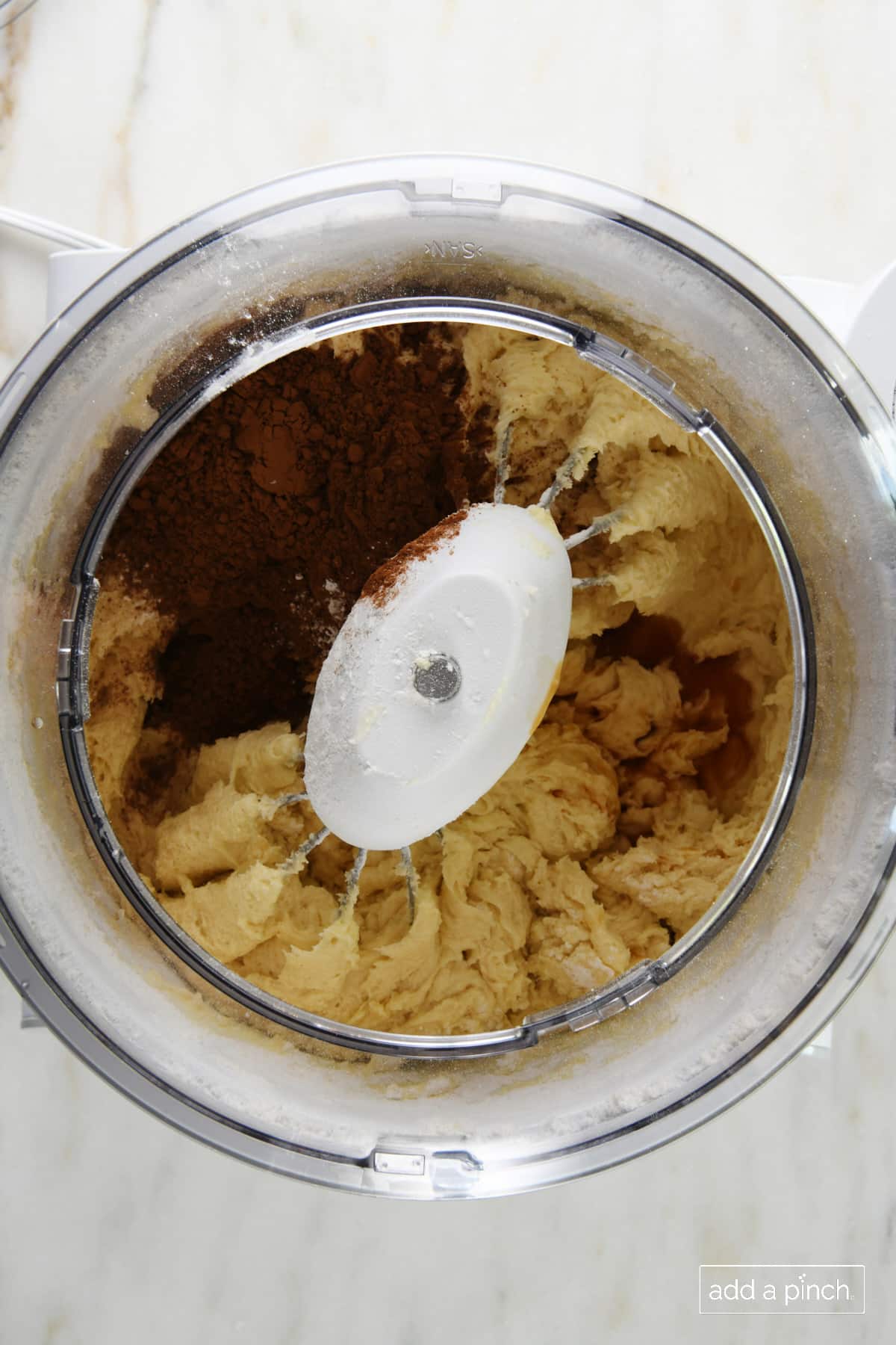 Add cocoa powder and vanilla extract to the cake batter in the mixer.