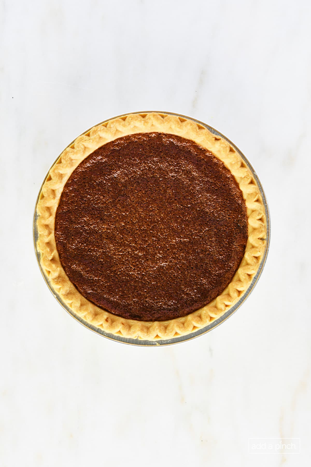 Baked chocolate chess pie on a marble surface.