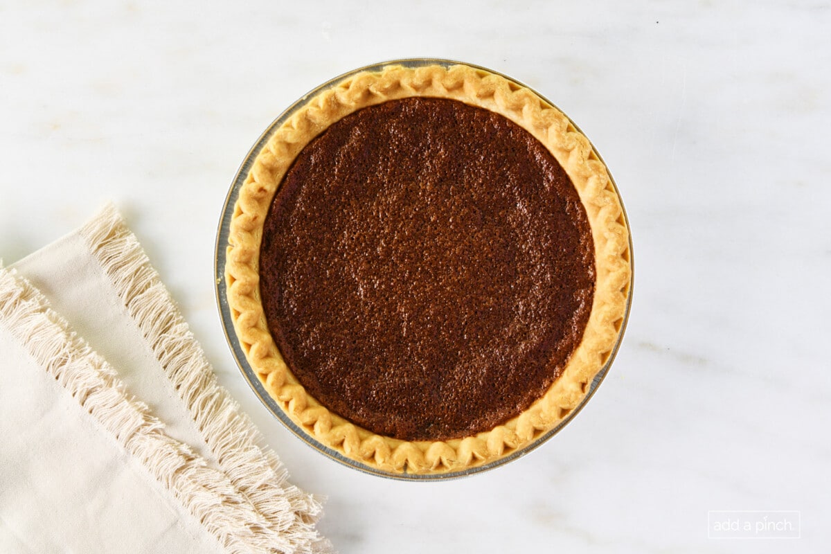Baked chocolate chess pie on a white marble surface with a linen napkin.