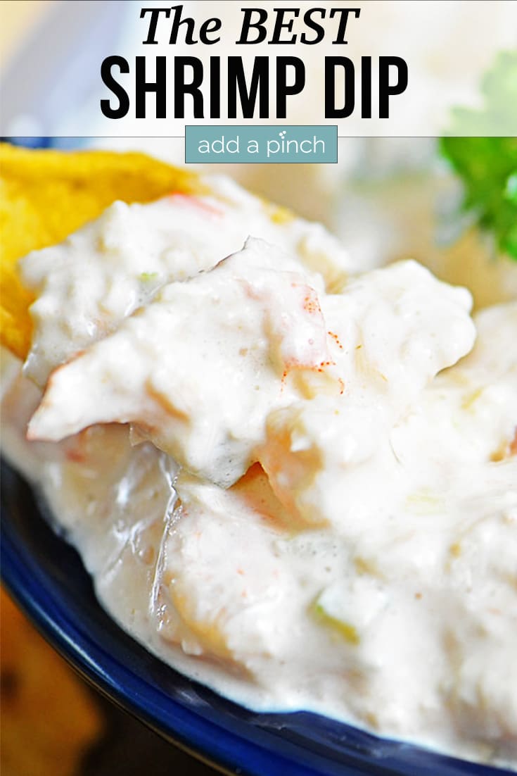 Shrimp Dip with a corn chip in a bowl - with text - addapinch.com