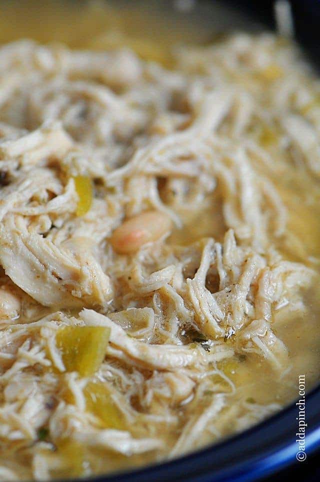 Bowl of chili with chicken, white beans, broth, and chilis.