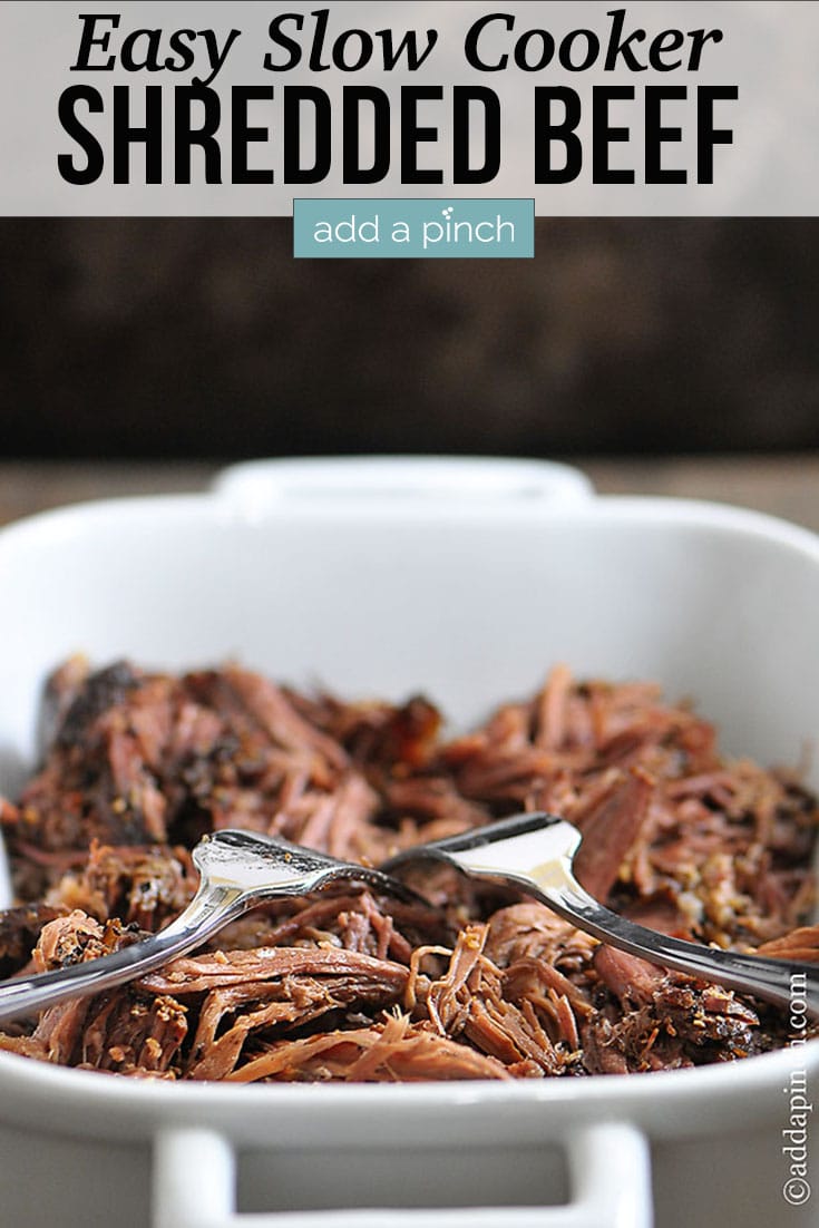 Shredded Beef with two forks in white casserole dish - with text - addapinch.com
