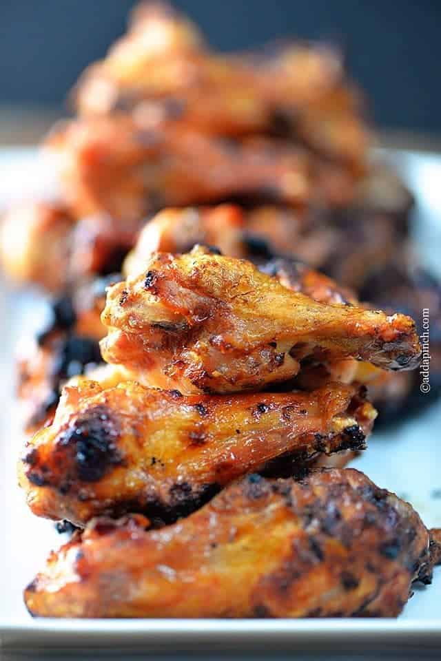 Smoked chicken wings lined on a white serving platter - addapinch.com