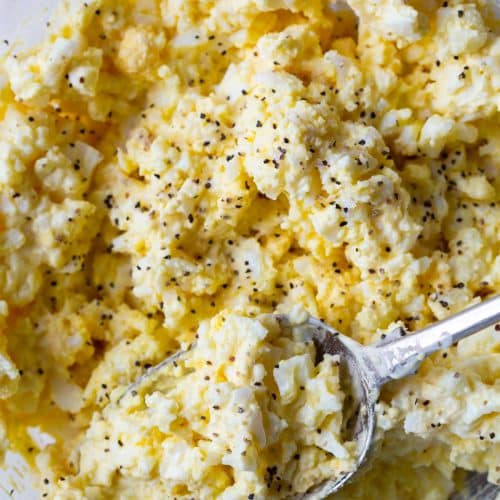 Classic egg salad in a bowl with a silver spoon.