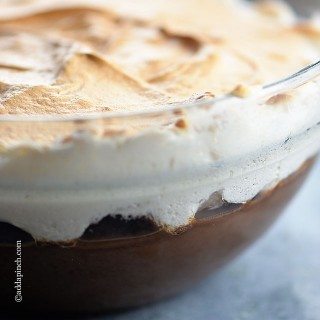 Chocolate pudding topped with meringue in a glass bowl