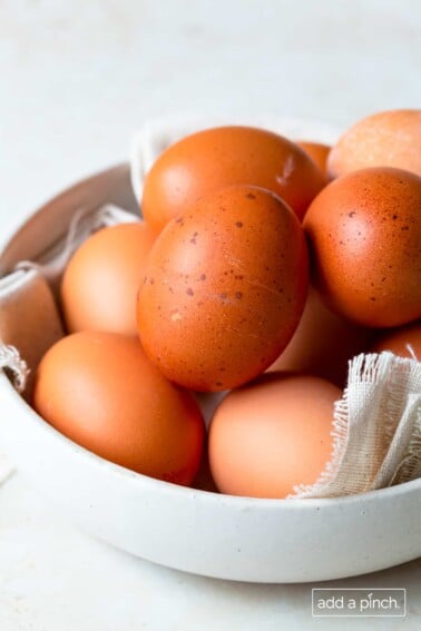 Eggs in a bowl on a white surface.