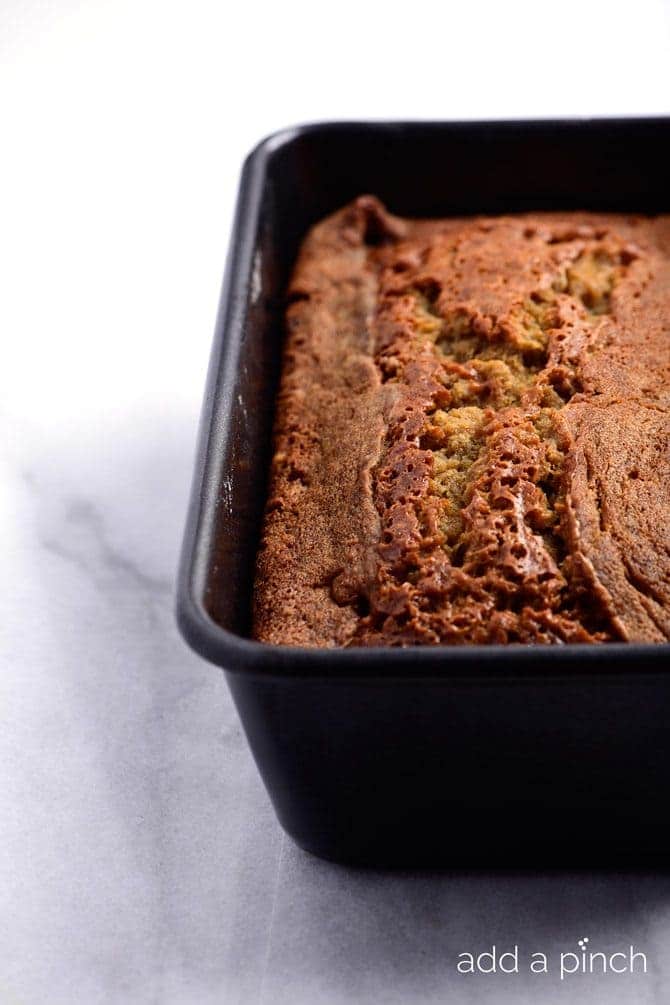 Loaf pan cooling on a white marble countertop. // addapinch.com