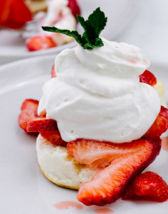 Strawberry Shortcake makes a classic dessert. Made of tender biscuits, topped with sweetened strawberries, and whipped cream, this simple strawberry shortcake is a favorite! // addapinch.com