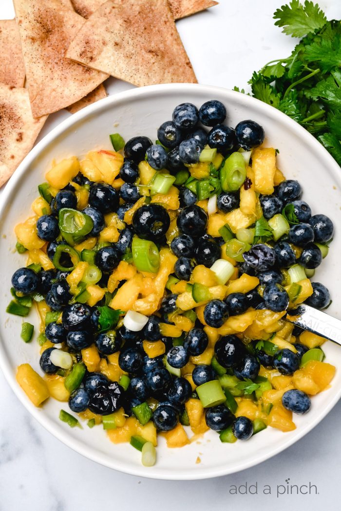 Blueberry Peach Salsa makes a delicious fruit salsa. Made of blueberries, peaches and a few other simple ingredients, this blueberry peach salsa is a summertime favorite. // addapinch.com