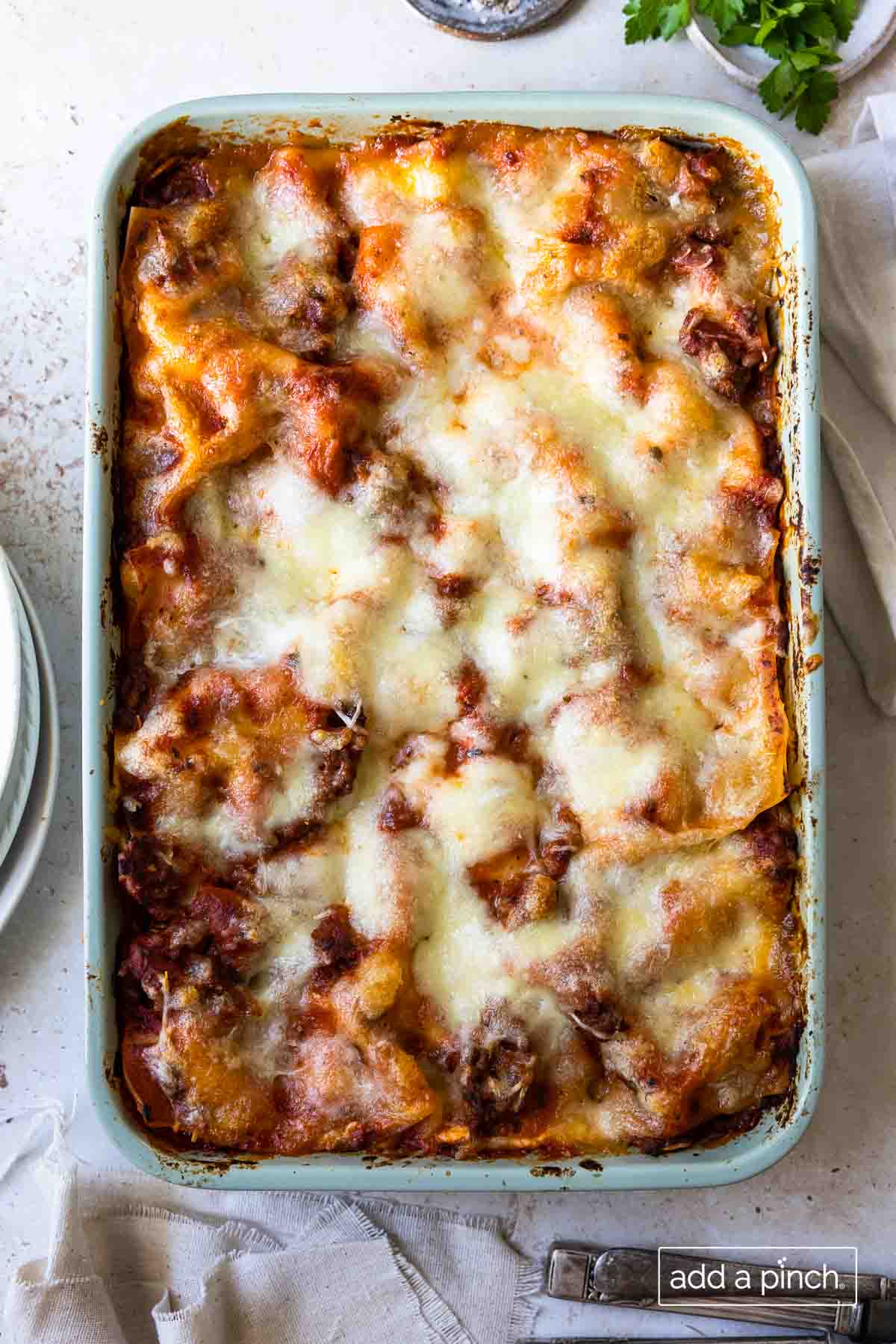 Image of baked lasagna in a 9x13 baking dish on a white background.