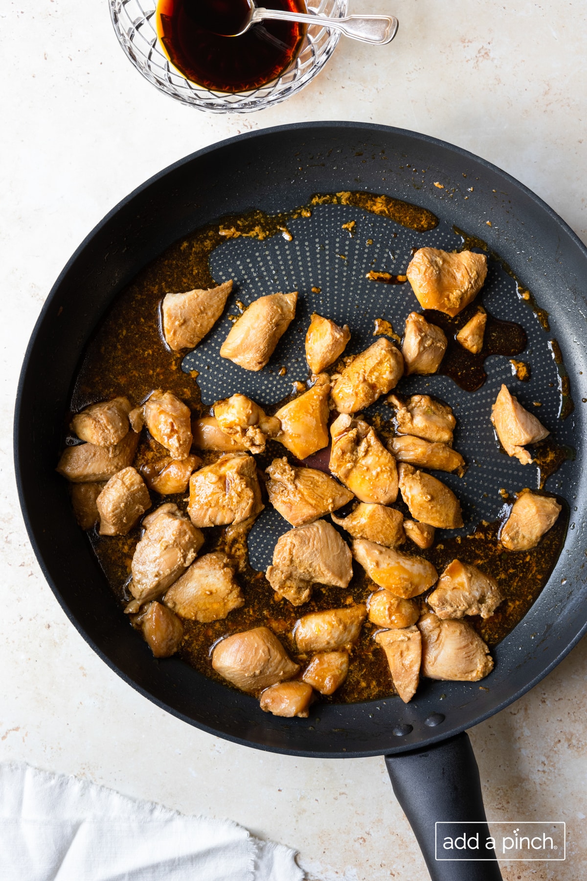 Chicken cooked in a skillet with teriyaki sauce.