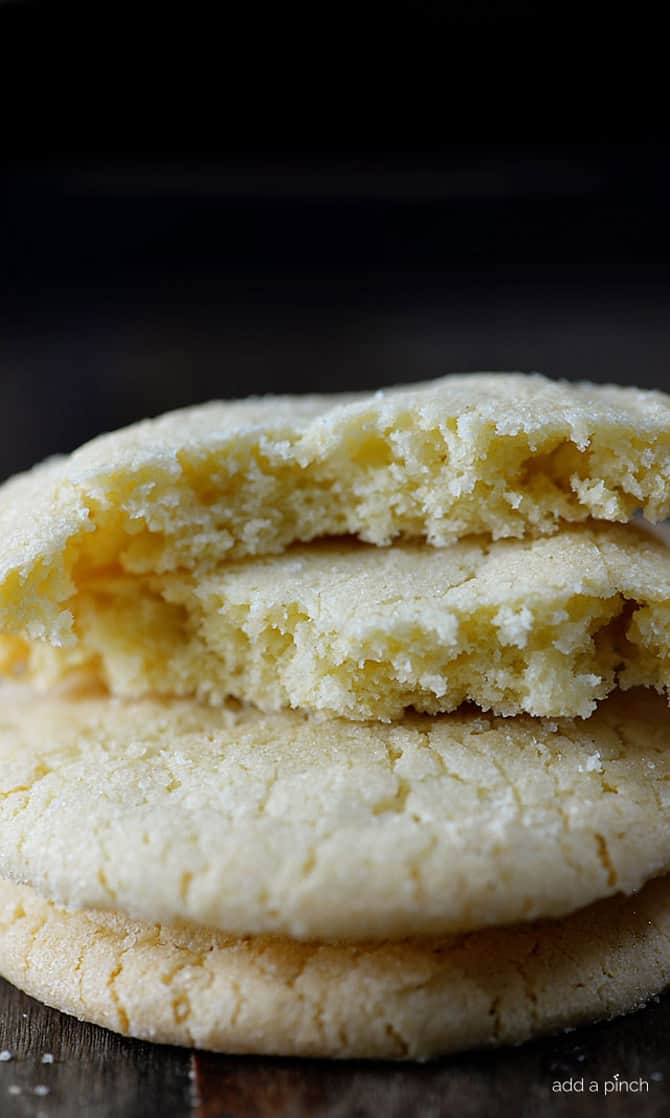 Stack of chewy sugar cookies on a wooden surface.