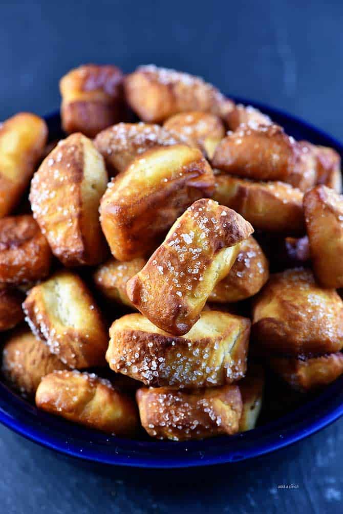 Pretzel Bites with salt crystals on top served in a blue bowl on stone background - from addapinch.com