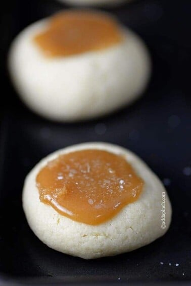 Salted Caramel Thumbprints Cookies make the perfect little cookie. Buttery thumbprints topped with delicious caramel make the best salted caramel thumbprints you'll love. // addapinch.com