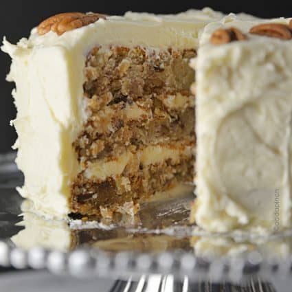 Photo of Hummingbird Cake with whole pecans on cream cheese frosting on pewter cake plate.