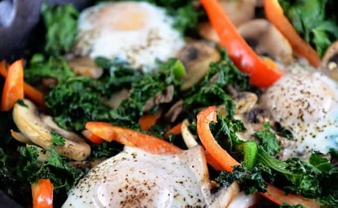 This kale breakfast skillet recipe is packed with flavor and ready in minutes! Made with kale, mushrooms, onions, peppers, and topped with eggs. // addapinch.com