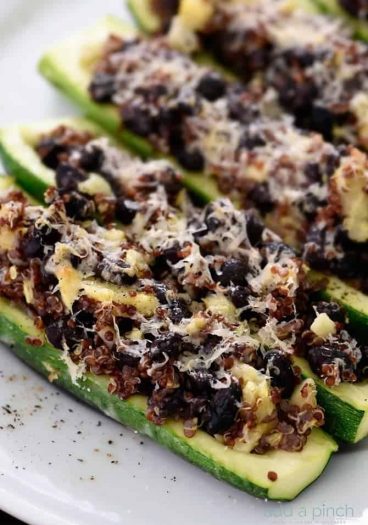 This stuffed zucchini recipe is a delicious dish made of zucchini stuffed with a mixture of black beans, quinoa, zucchini and topped with parmesan. It is definitely a filling favorite! // addapinch.com