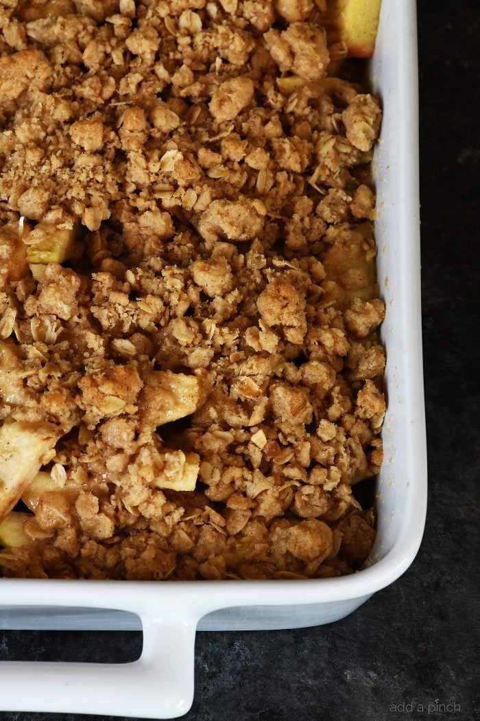 Baking dish of freshly baked Apple Crisp with golden brown streusel topping - addapinch.com