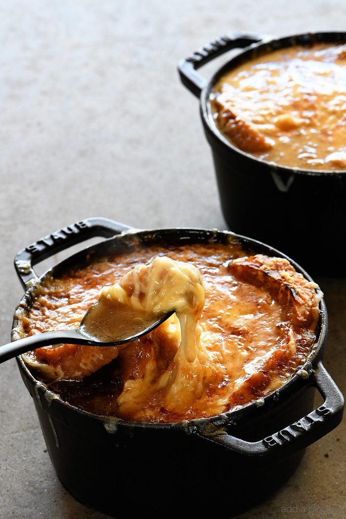 French Onion Soup makes a comforting, classic bowl of soup! Made with caramelized onions a slice of crusty bread and melty, delicious cheese! Includes stovetop and slow cooker methods! // addapinch.com