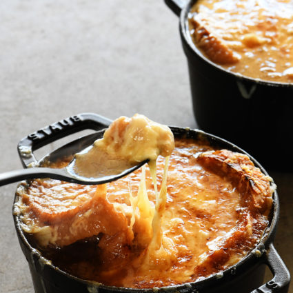 French Onion Soup makes a comforting, classic bowl of soup! Made with caramelized onions a slice of crusty bread and melty, delicious cheese! Includes stovetop and slow cooker methods! // addapinch.com
