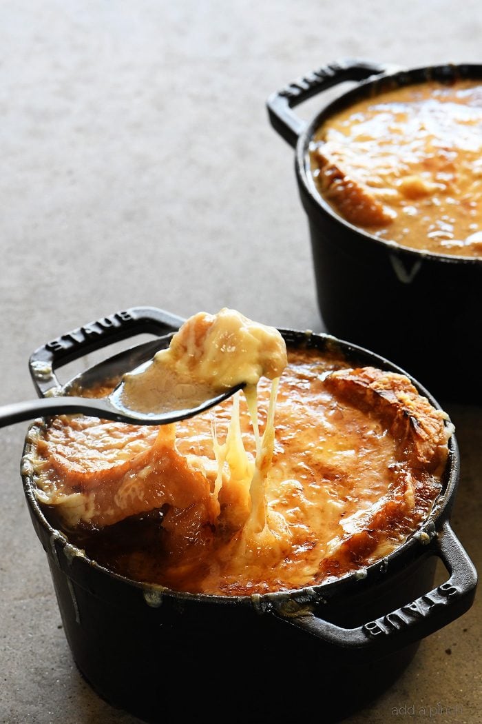 French Onion Soup makes a comforting, classic bowl of soup! Made with caramelized onions a slice of crusty bread and melty, delicious cheese! Includes stovetop and slow cooker methods! // addapinch.com