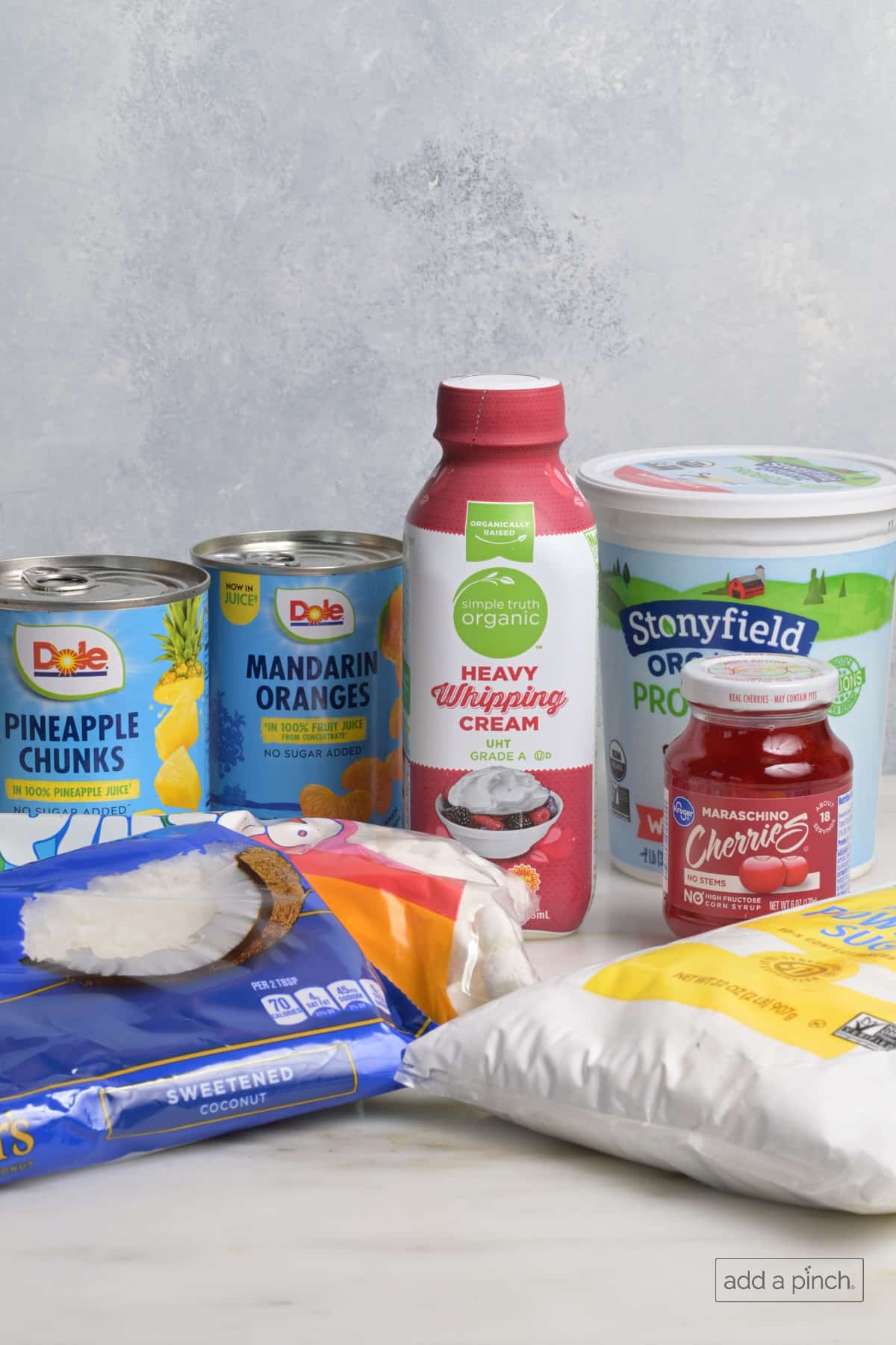 Ingredients used to make ambrosia salad on a marble counter.