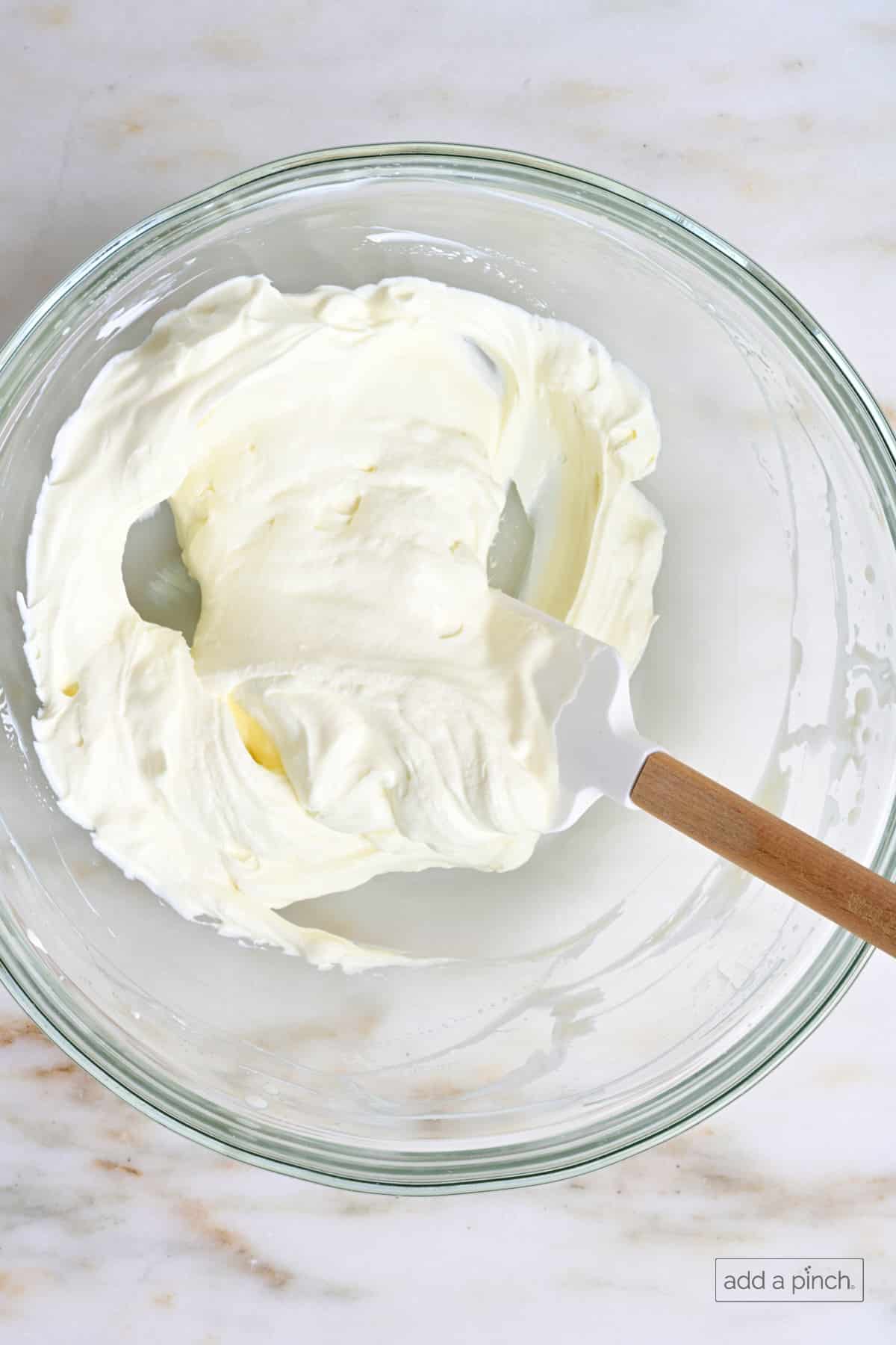 Folded whipped cream to make the creamy dressing for ambrosia.