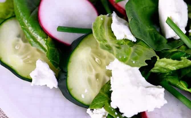 This Spinach Romaine Salad recipe makes a delicious welcome to spring! Topped with radishes, cucumbers, feta, and chives, it is sure to be a favorite! // addapinch.com