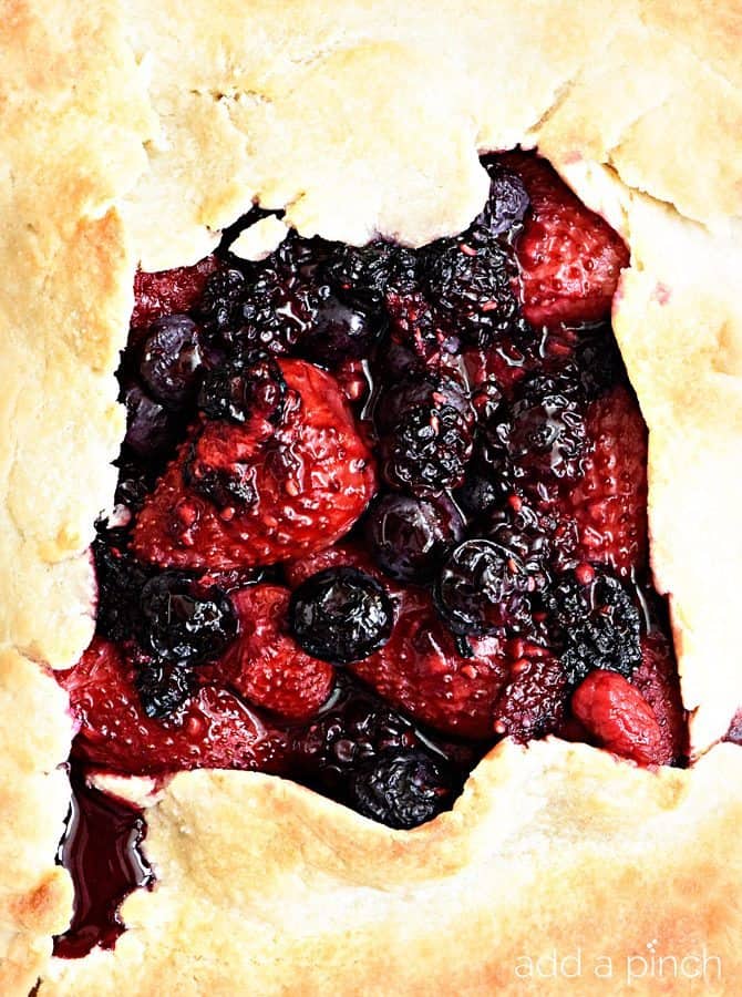 Rustic Mixed Berry Tart Recipe - This Rustic Mixed Berry Tart recipe makes a delicious dessert recipe perfect for a simple weeknight supper! Made of strawberries, blueberries and blackberries and sweetened with honey. So easy! // addapinch.com