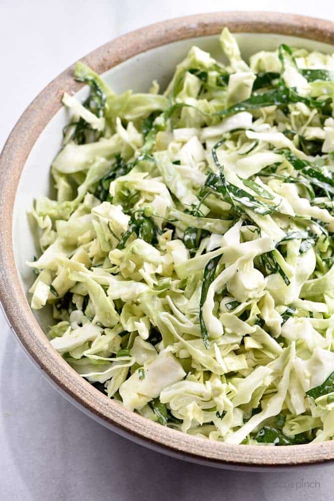 Cabbage and Collard Coleslaw Recipe - Cabbage and Collard Coleslaw makes a quick, easy and delicious coleslaw recipe! Made with fresh cabbage, collard greens, onions and a tangy dressing! // addapinch.com