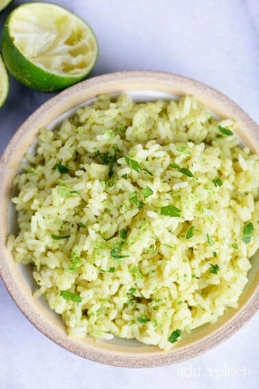 Cilantro Lime Rice in a white bowl with limes. // addapinch.com