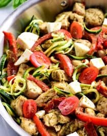 One Pan Pesto Chicken Recipe - This One Pan Pesto Chicken recipe makes a quick and easy answer to what's for supper? Made with chicken, pesto, peppers, tomatoes, zucchini and mozzarella, this will easily become a favorite! // addapinch.com