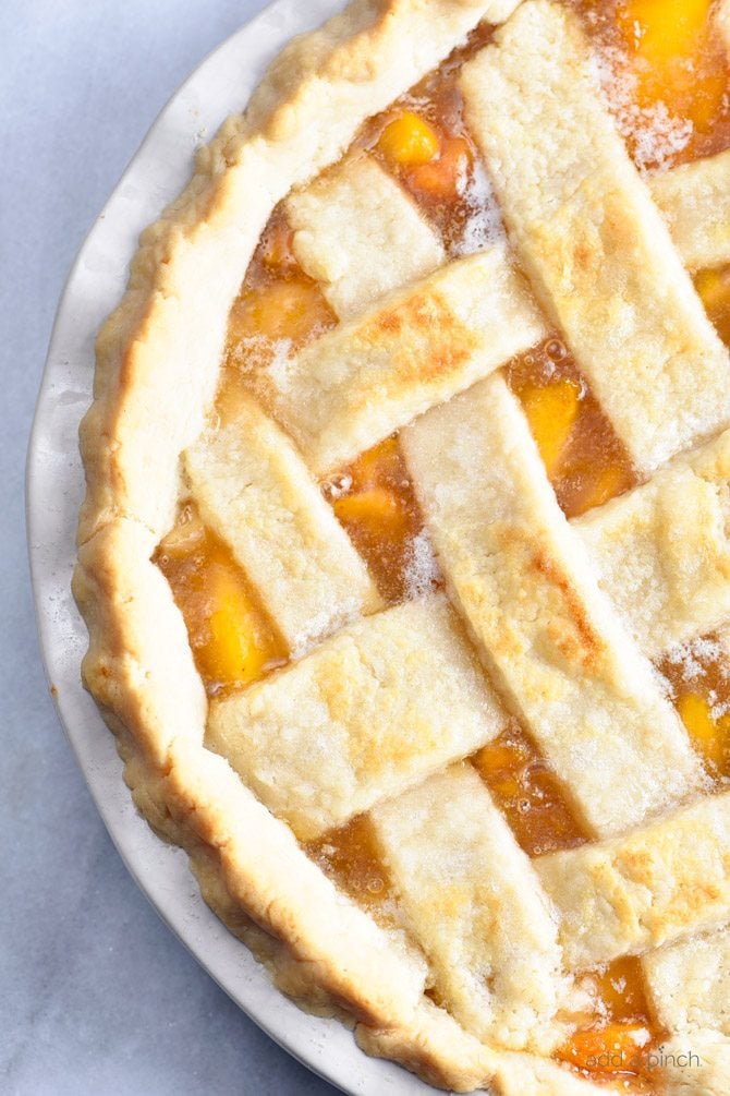 Classic Peach Pie Recipe - This Classic Peach Pie Recipe is a summer staple! Made with a lattice-topped double crust and filled with delicious peaches! // addapinch.com