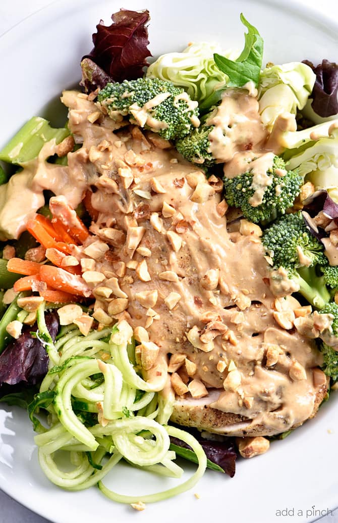Asian Chicken Salad Recipe - This Asian chicken salad recipe is filled to the brim with flavor! A crisp salad topped with tender chicken, vegetables and a delicious peanut sauce for dressing! // addapinch.com