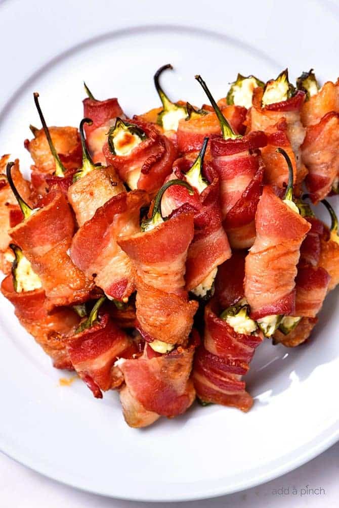 Bacon Wrapped Jalapeno Poppers Recipe - Bacon Wrapped Jalapeno Poppers make an appetizer that everyone loves! This easy recipe combines creamy cheeses, spicy jalapenos and crispy bacon for classic baked jalapeno poppers that are irresistible! // addapinch.com