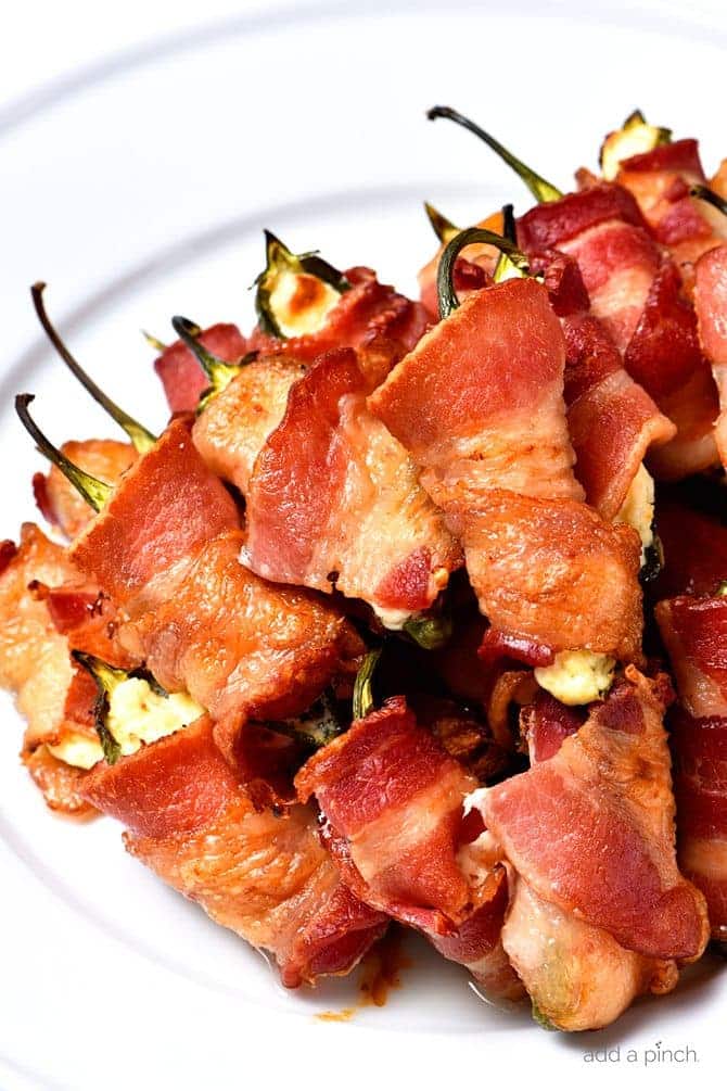 Bacon Wrapped Jalapeno Poppers Recipe - Bacon Wrapped Jalapeno Poppers make an appetizer that everyone loves! This easy recipe combines creamy cheeses, spicy jalapenos and crispy bacon for classic baked jalapeno poppers that are irresistible! // addapinch.com