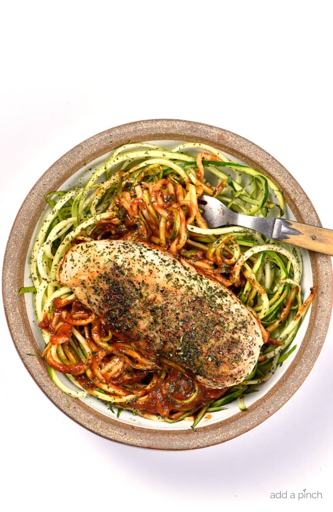 Brown edge serving plate holds zucchini noodles with seasoned chicken breast