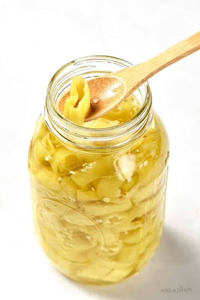 Receta fácil de pimientos en escabeche - ¡Esta receta de pimientos en escabeche es una forma rápida y fácil de conservar tu plátano, jalapeño y otros tipos de pimientos! Perfectos para usar durante todo el año en platos como pizzas, sopas, ensaladas, sándwiches y muchos más. // addapinch.com