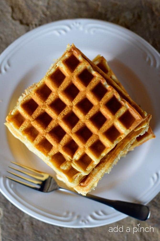 Crispy, golden Buttermilk Waffles fresh from the waffle iron without syrup // addapinch.com