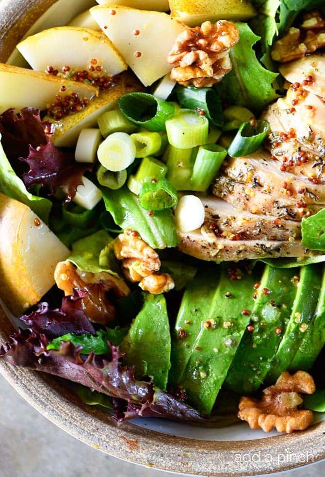 Fall Chicken Avocado Pear Salad Recipe - This salad makes for a delicious fall salad recipe! Filled with chicken, avocado, pears, walnuts, and topped with a Honey Mustard Dressing! // addapinch.com