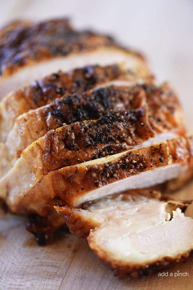 Photo of turkey breast sliced on a cutting board.